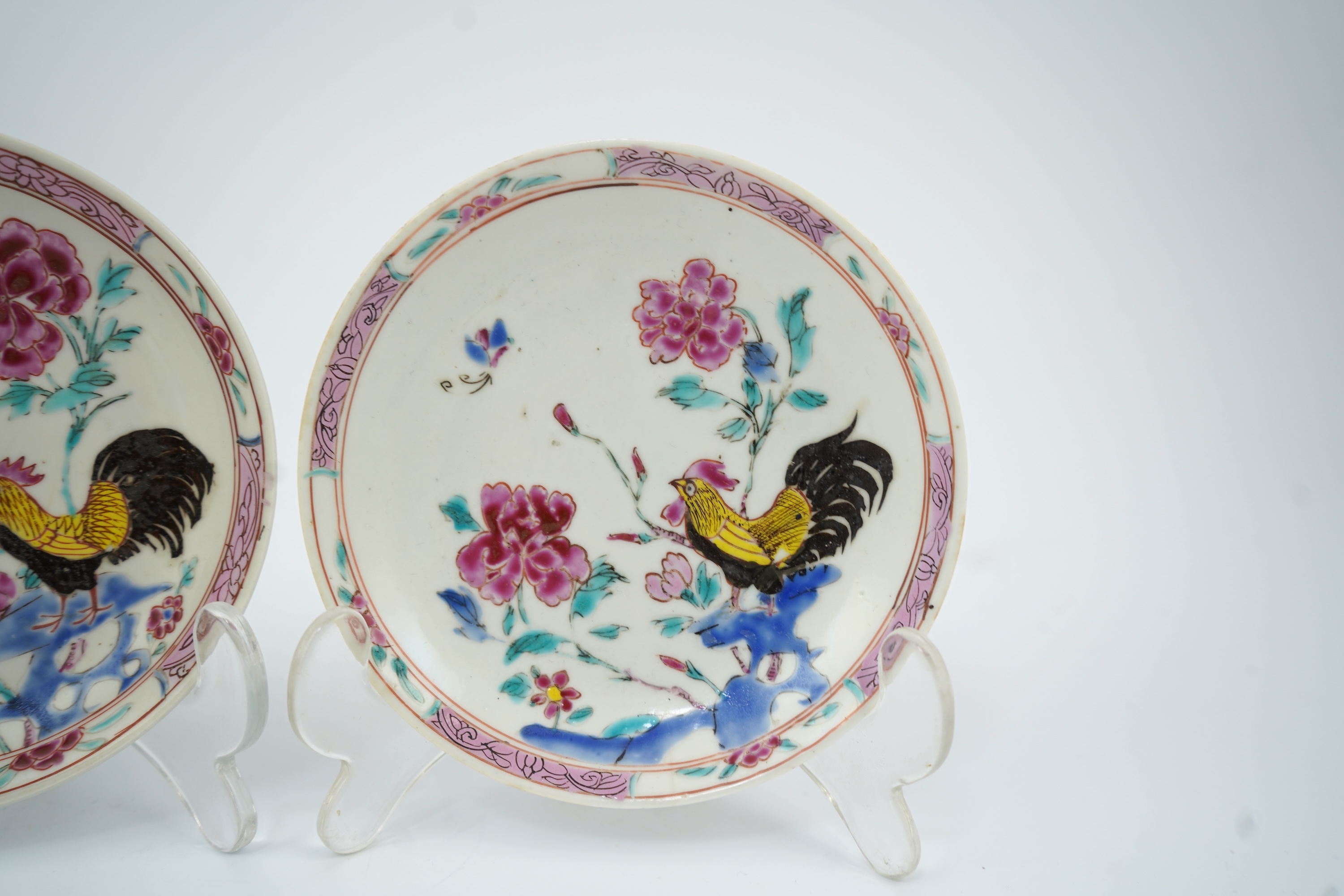A near pair of Chinese famille rose ‘cockerel’ tea bowls and saucers, Yongzheng period